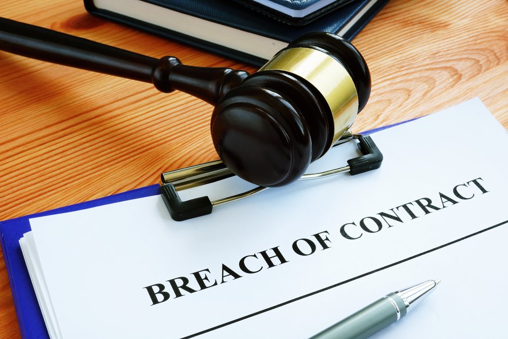 breach of contract papers with pen and gavel